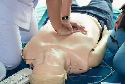 Hands performing chest compressions on a CPR training mannequin