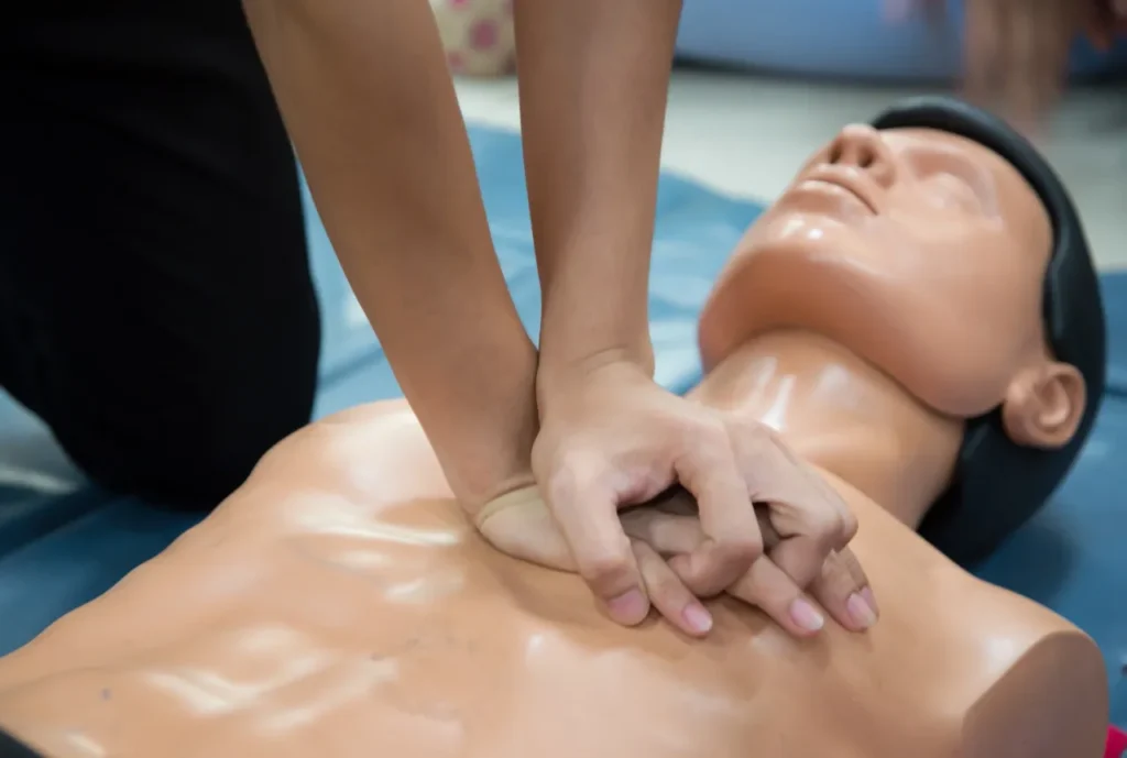 Close-up of hands performing CPR chest compressions on a training mannequin
