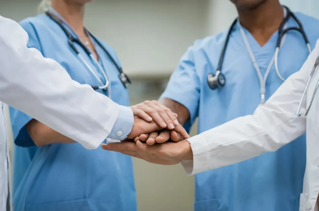 Healthcare professionals stacking hands together as a team
